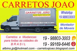 Caminhão de mudanças "Carretos João" com contatos e serviços exibidos em cartaz amarelo.