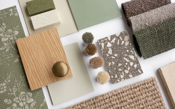 Eine Kollektion verschiedener nachhaltiger Materialen. Unter anderem ein helles Stück Holz, verschiedenen Stücken Stoff mit unterschiedlichen Strukturen und verschiedene Bodenbeläge