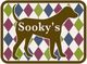 Brauner Hund vor farbigem Rautenmuster mit dem Schriftzug „Sooky's“.