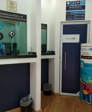 Recepção de agência com balcão de atendimento, mesinhas e porta marcada como "Sala VIP".