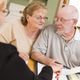 Elderly couple reviewing documents with a professional at a table.