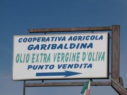 Insegna con testo: "Cooperativa Agricola Garibaldina, Olio Extra Vergine d'Oliva, Punto Vendita".