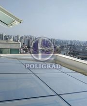 Cobertura de vidro sobre cidade, vista de arranha-céus ao fundo.