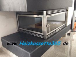 Kamin mit Glastür in modernem Design, neben Schriftzug "www.Heizkassette365.de".