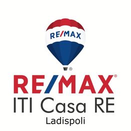 Logo RE/MAX con mongolfiera e testo: "ITI Casa RE Ladispoli".