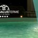 Piscina termale illuminata con scritta "HOTEL SALUS TERME VITERBO" e slogan di benessere.