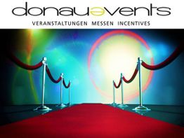 Roter Teppich mit Absperrung, bunte Lichtkreise im Hintergrund, Logo: donau events.