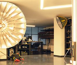 Fotostudio mit großem, beleuchtetem Schirm und Ausrüstung in modernem Raum.