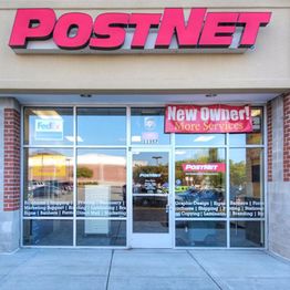 Storefront of PostNet with a sign announcing "New Owner! More Services."