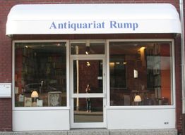 Eingang eines Antiquariats mit der Aufschrift "Antiquariat Rump" auf der Markise.