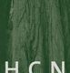 Baumrinde in Nahaufnahme mit großen, weißen Buchstaben "HCN" im Vordergrund.