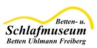 Logo des Betten- und Schlafmuseums Freiberg mit gelber Kurve und Schriftzug.