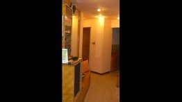 Corridoio interno con illuminazione calda e pareti color crema. Arredamento semplice e accogliente.