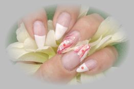 Nahaufnahme von Fingernägeln mit French Maniküre und Blumenmuster auf einer Blüte.