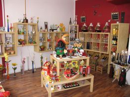 Kleiner Laden mit Regalen voller Souvenirs, Flaschen und Dekorationsartikeln in bunten Farben.