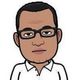 Cartoon avatar of a person wearing glasses and a white shirt, with short black hair.