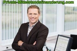 Mann im Büro mit braunem Sakko, lächelnd, Computer im Hintergrund.