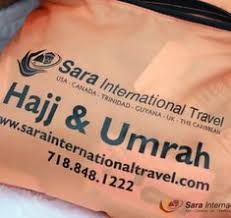 Orange bag with "Sara International Travel" and "Hajj & Umrah" details printed in black.