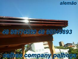 Telhado de madeira e calha com texto: "alemão" e contatos "48 96174569" e "48 85049893".