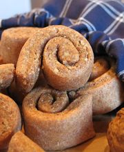 Vollkorngebäck aus einer blau karierten Serviette auf Holztisch.