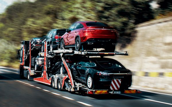 Autotransporter eines Abschleppunternehmens überführt verschiedene Automodelle für ein Autohaus.