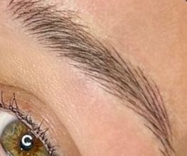 Close-up van een groen oog met lange wimpers en een goed gevormde wenkbrauw.