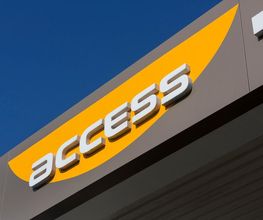 Gebäudewand mit gelbem Schild und dem Wort "access" in weißen Buchstaben vor blauem Himmel.
