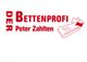 Der Schriftzug "Der Bettenprofi Peter Zahlten" neben einer Matratze und zwei Kissen, alles in Rot.