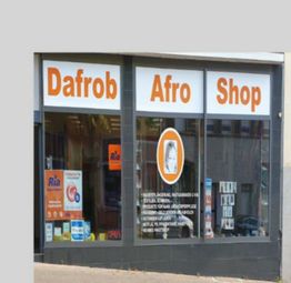 Außenansicht eines Geschäfts mit der Aufschrift "Dafrob Afro Shop" und Schaufensterdekoration.