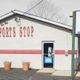 Small building labeled "Sports Stop" with pots outside and a visible glass door.
