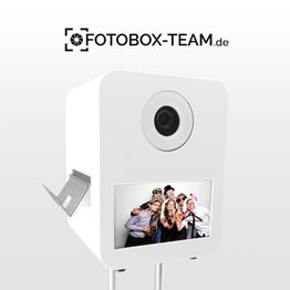 Fotobox mit Display und Foto von fröhlichen Menschen. Logo "Fotobox-Team.de" oben.