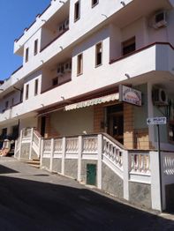 Edificio bianco su strada, con insegna "Hotel Florida" e una freccia verso il mare.