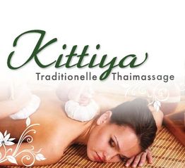 Frau liegt bei traditioneller Thaimassage mit Kräuterkompressen. "Kittiya" Schriftzug oben.