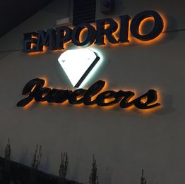 Sign reading "EMPORIO Jewelers" with a glowing diamond design on a wall.