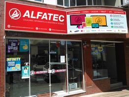 Fachada da loja ALFATEC com letreiro e propaganda de produtos eletrônicos e assistência técnica.