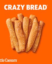 Palitos de pan Crazy Bread de Little Caesars sobre un fondo naranja.