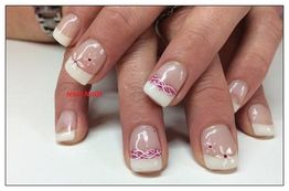 Nahaufnahme von Händen mit weiß-pinkem Nageldesign und dezenten Verzierungen.