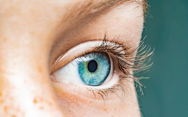 Nahaufnahme eines Auges einer Frau, die ihre blaue Iris fotografieren lassen möchte.