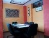 Sala riunioni con tavolo rettangolare, sedie nere e pareti colorate con opere d'arte.