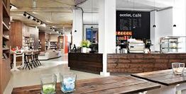 Gemütliches Café-Interieur mit Holzmöbeln und einer Theke, Bücherregale im Hintergrund.