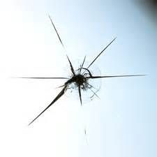 Cracked glass with radiating lines against a light background.