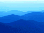 Blaue Hügel im Nebel, die allmählich heller werden und einen sanften Farbverlauf bilden.