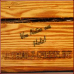 Holzkiste mit der Aufschrift "Von Natur aus Holz!" und unleserlichem Text darunter.