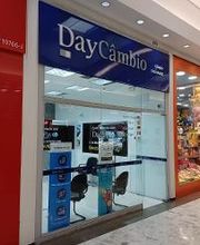 Loja de câmbio em um shopping, com vitrines ao lado e uma pessoa passando em frente.