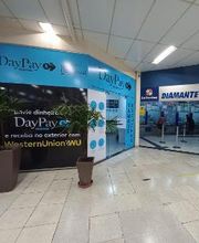 Corredor de shopping com fachada da DayPay à esquerda e lotérica Diamante à direita.
