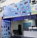 Fachada de loja de informática com letreiro azul e imagens de produtos eletrônicos.