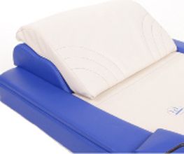Blaue und weiße Matratze mit erhöhtem Kopfteil aus weichem Material, seitliche Erhöhungen.