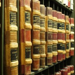 Row of vintage leather-bound books on a bookshelf.