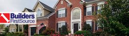 Red brick house with a Builders FirstSource logo in the corner.