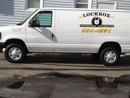 White locksmith van parked, displaying "Lockbox Professional Locksmiths" with contact number.